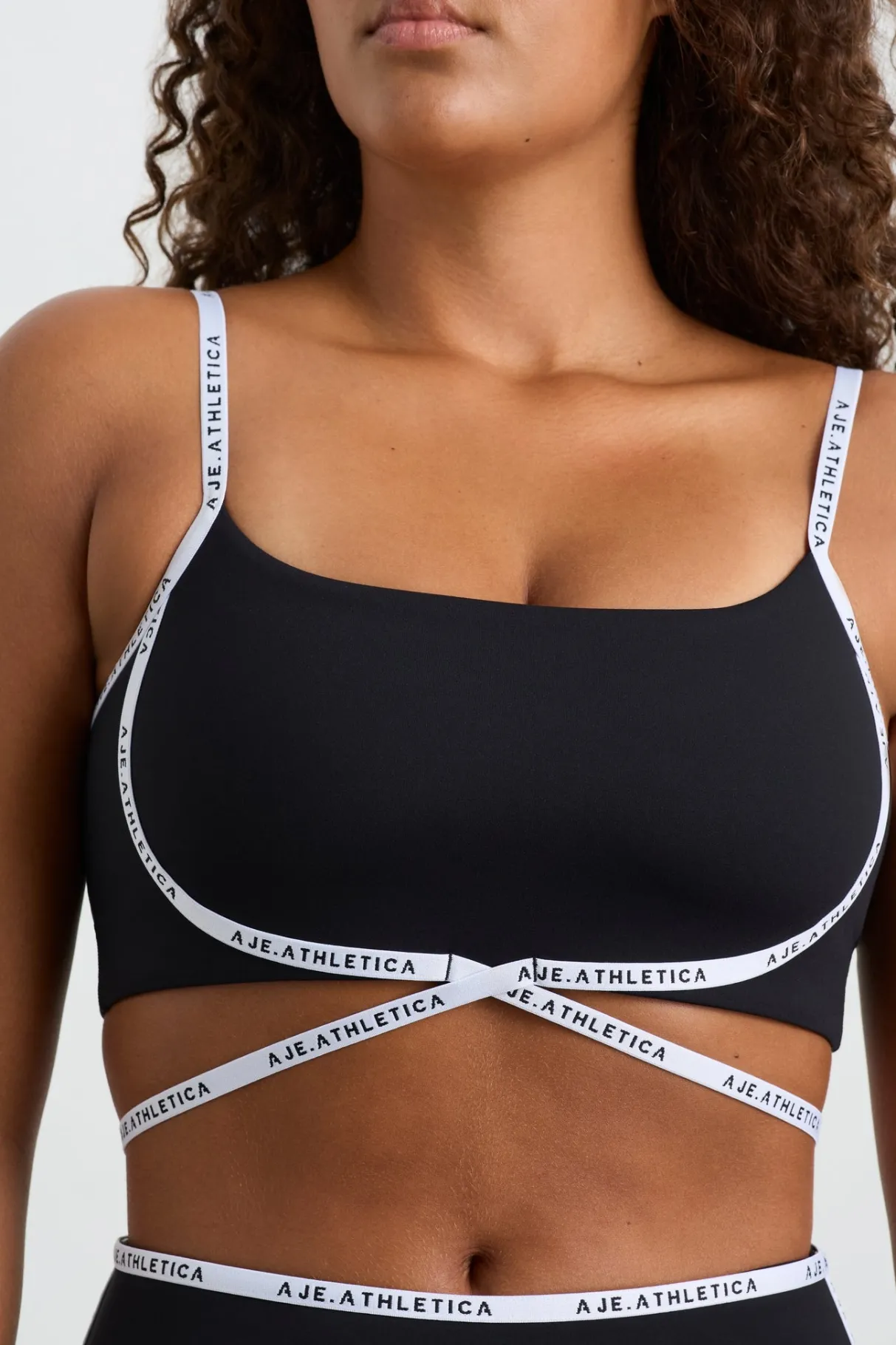 logo_tape_crossover_bra__7.webp Outlet Aje ATHLETICA Logo Tape Crossover Bra 393 Black/White